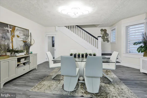a dining room with wooden floor and white walls