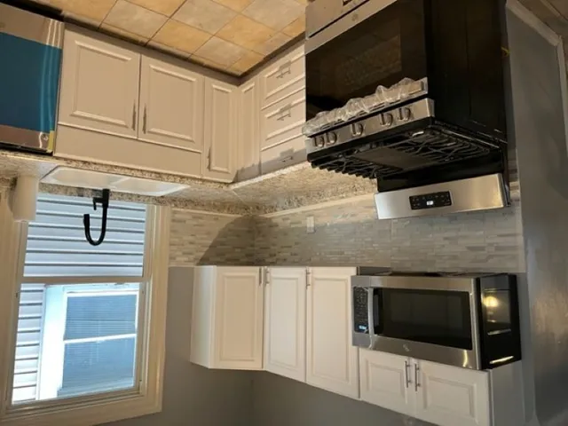 a kitchen with granite countertop a stove and a microwave