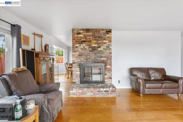 a kitchen with stainless steel appliances granite countertop a stove top oven a sink a dining table and chairs with wooden floor