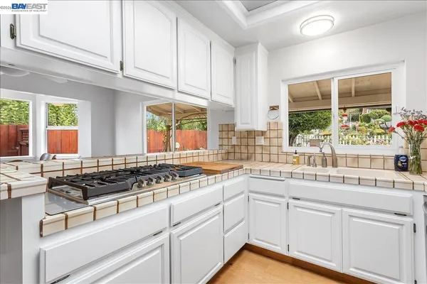 a kitchen with stainless steel appliances granite countertop a refrigerator a stove and a sink