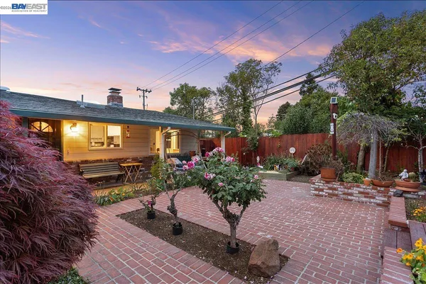 a view of a house with a yard and potted plants
