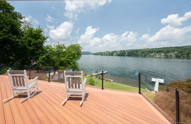 a view of a lake with couches and wooden floor