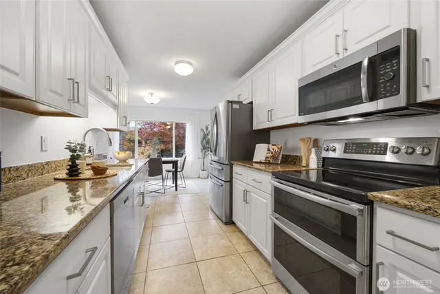 a kitchen with stainless steel appliances granite countertop a sink and stove top oven