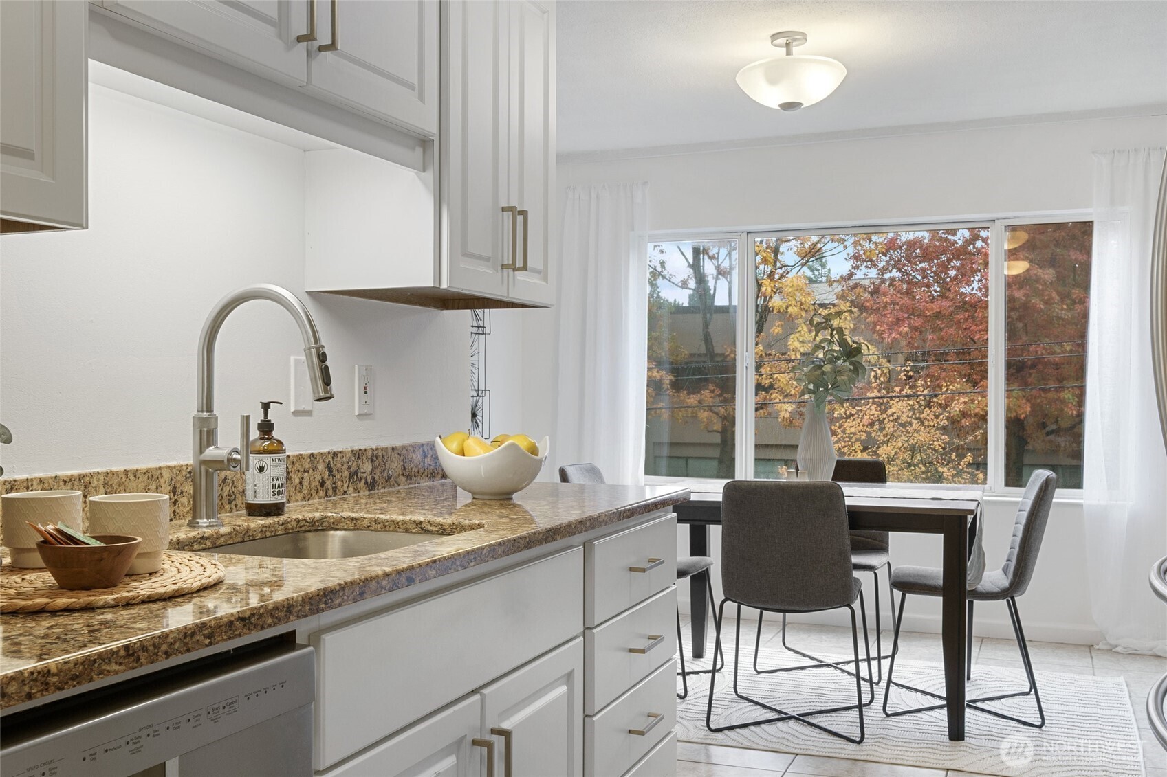 4545 Sand Point Way Northeast, Unit 203 Seattle, WA 98105 - Photo 14 of 28 a dining table with a large window and white kitchen