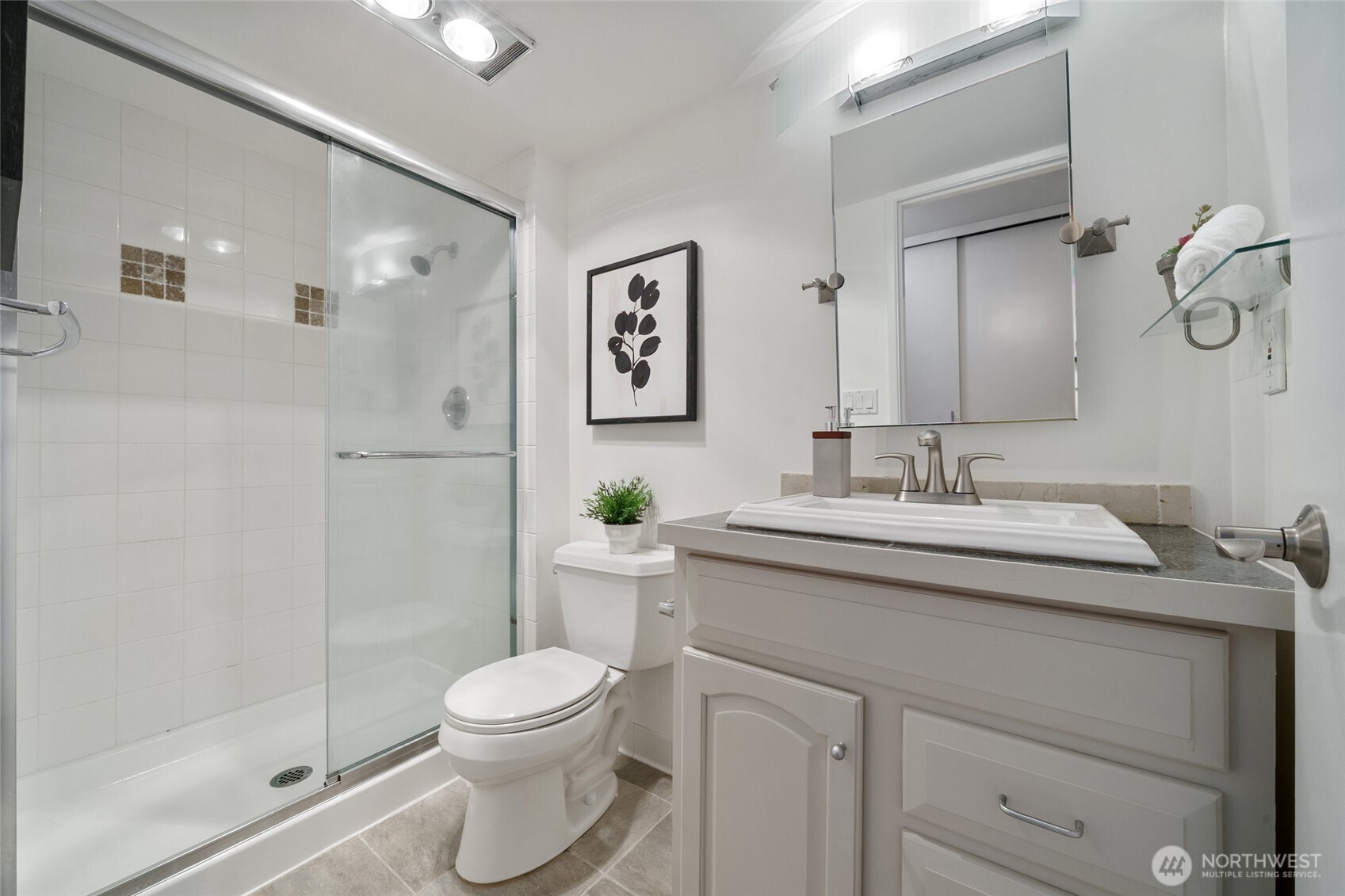 4545 Sand Point Way Northeast, Unit 203 Seattle, WA 98105 - Photo 21 of 28 a bathroom with a granite countertop sink toilet a mirror and shower