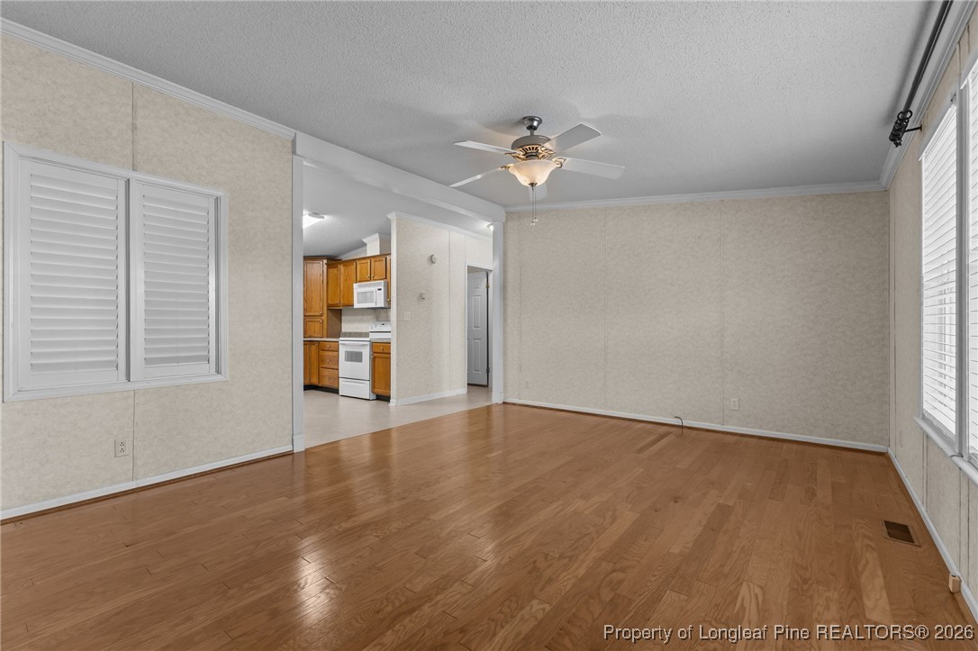 355 Rock Hill Road Fayetteville, NC 28312 - Photo 13 of 38 a view of an empty room with a window and wooden floor