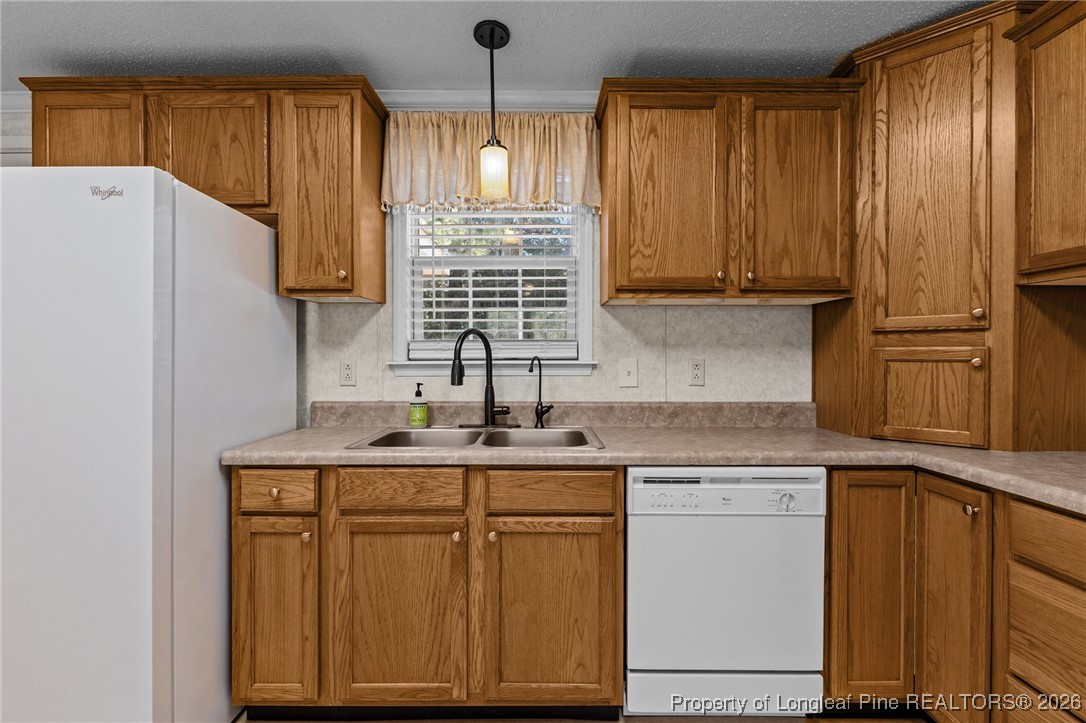 355 Rock Hill Road Fayetteville, NC 28312 - Photo 19 of 38 a kitchen with kitchen island granite countertop wooden cabinets and white appliances