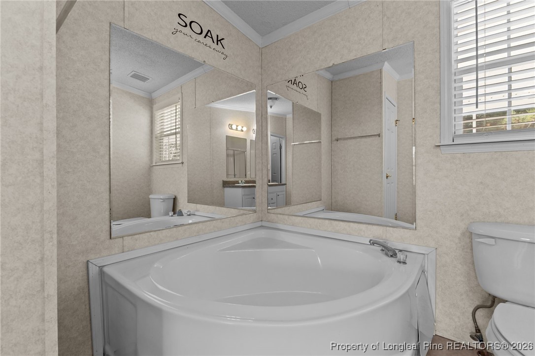 355 Rock Hill Road Fayetteville, NC 28312 - Photo 25 of 38 a bathroom with a granite countertop sink mirror vanity and toilet