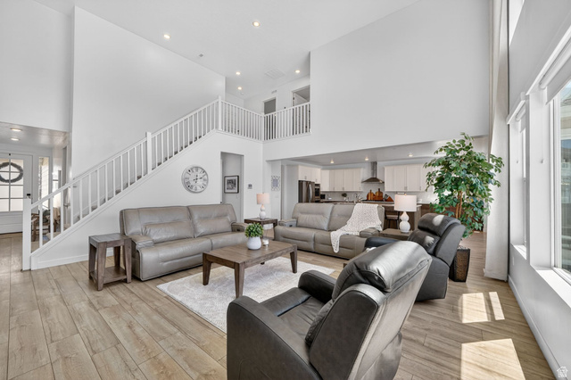 1165 West Union Bench Drive Mapleton, UT 84664 - Photo 10 of 61 Spacious living room featuring high ceilings, wood-finish flooring, recessed lighting, and a prominent staircase with white railings