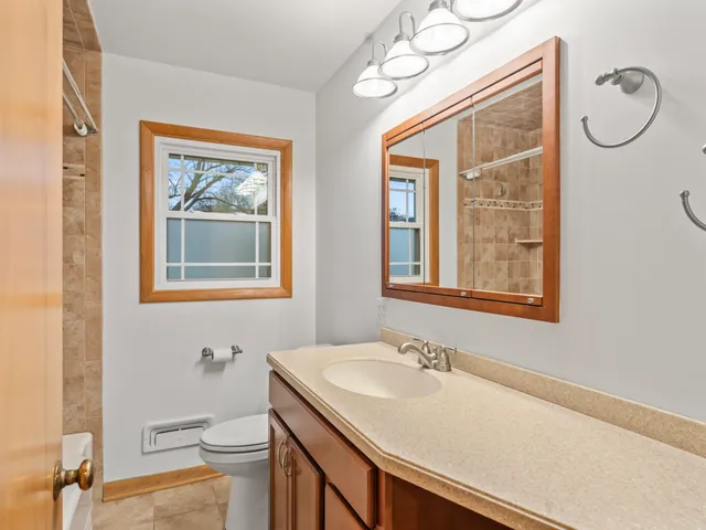 a bathroom with a granite countertop sink a toilet and a mirror