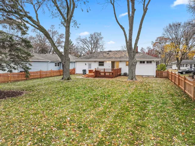 a front view of a building with large trees and a large tree