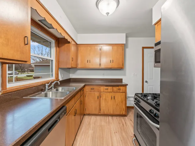 a kitchen with stainless steel appliances a sink dishwasher stove and oven