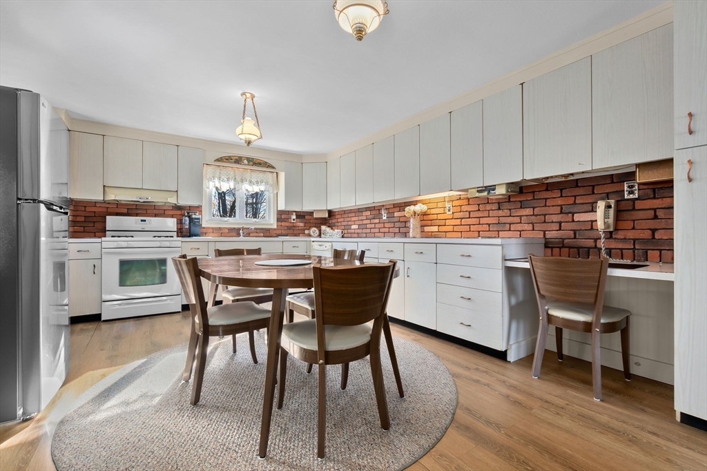 1 Robert Road Danvers, MA 01923 - Photo 10 of 39 a kitchen with stainless steel appliances a dining table chairs and wooden floor