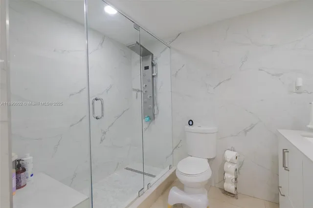a white toilet sitting next to a bath tub and shower