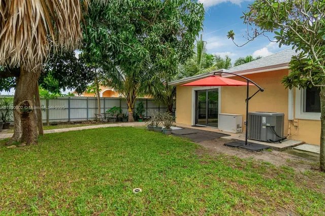 a view of a house with backyard and sitting area