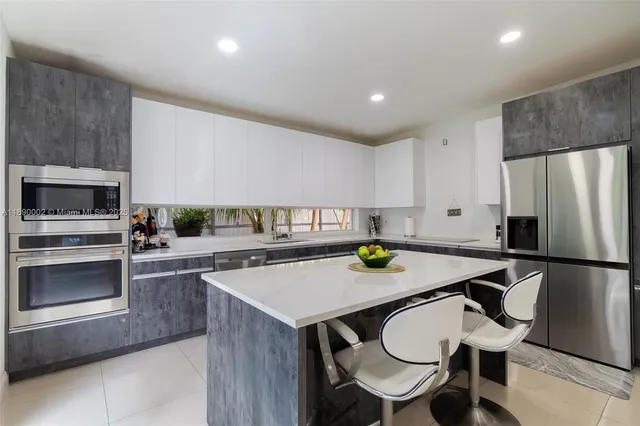 a kitchen with a sink a stove and chairs
