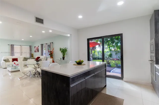 a room with a table chairs and a view of kitchen
