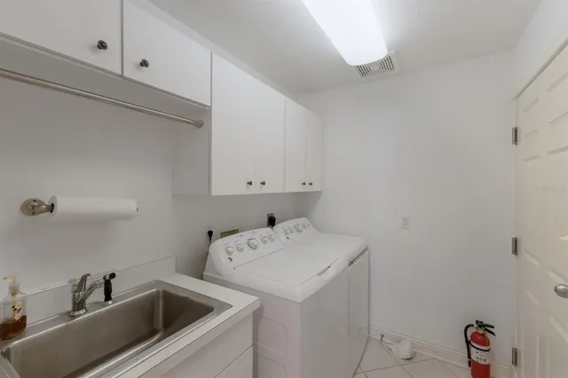 a view of a patio with a table and chairs under an umbrella with wooden fence