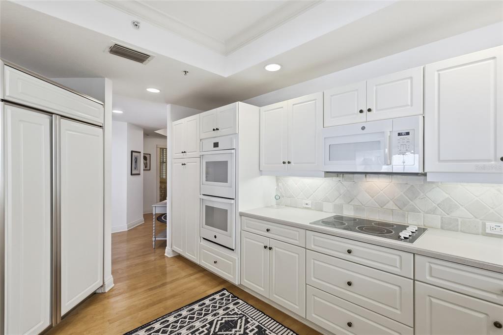 831 Harborshore Drive, Unit 1 Boca Grande, FL 33921 - Photo 10 of 81 a kitchen with granite countertop white cabinets and refrigerator