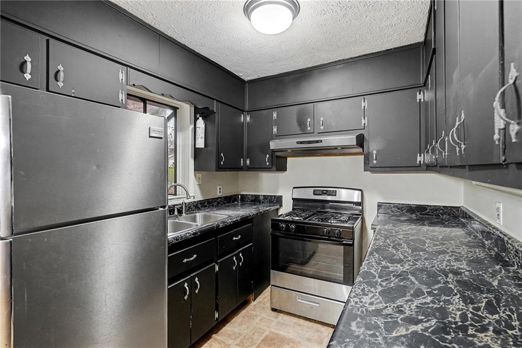 1995 Matt Drive Austell, GA 30168 - Photo 13 of 34 a kitchen with granite countertop a refrigerator and a stove top oven