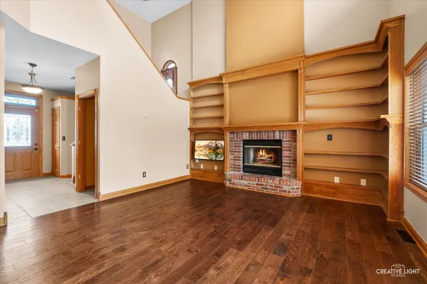 a view of a big room with wooden floor and windows