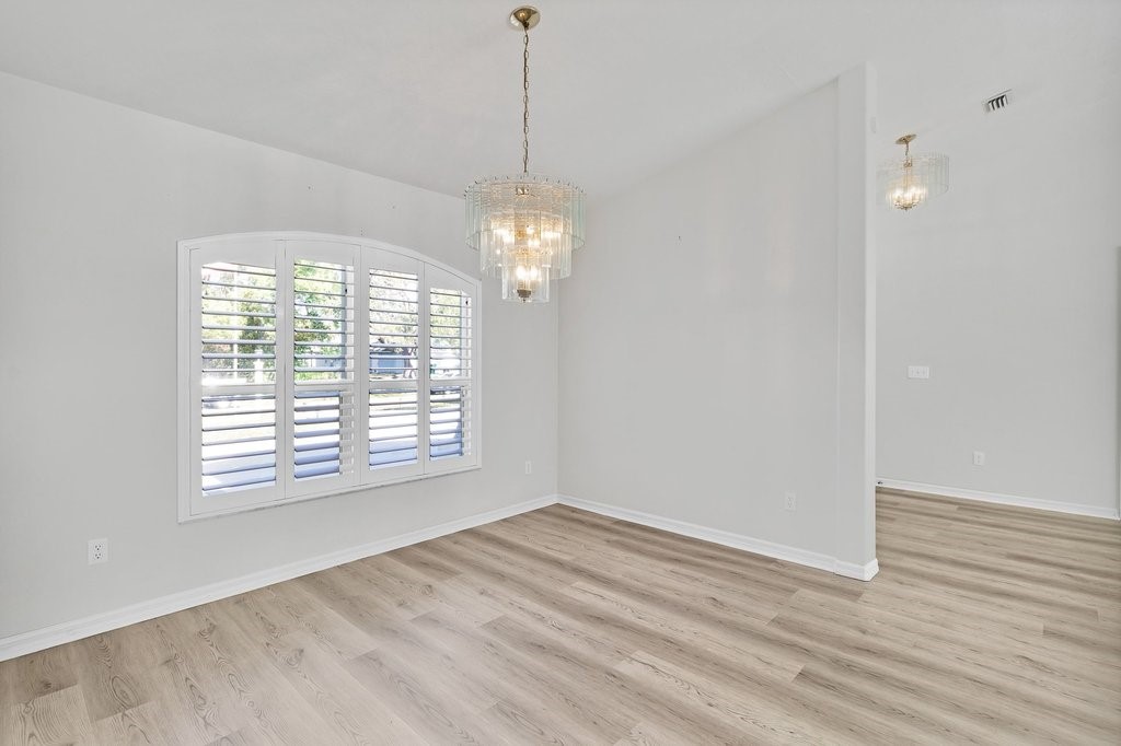 738 Benedictine Terrace Sebastian, FL 32958 - Photo 11 of 33 a view of an empty room with wooden floor and a window