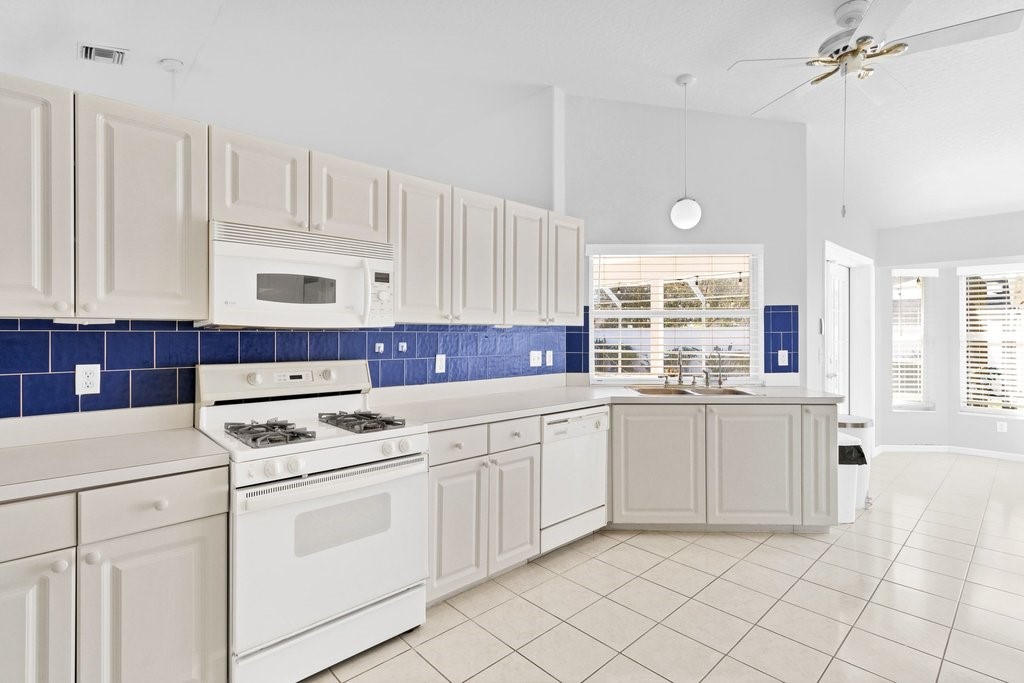738 Benedictine Terrace Sebastian, FL 32958 - Photo 6 of 33 a kitchen with granite countertop white cabinets and white appliances