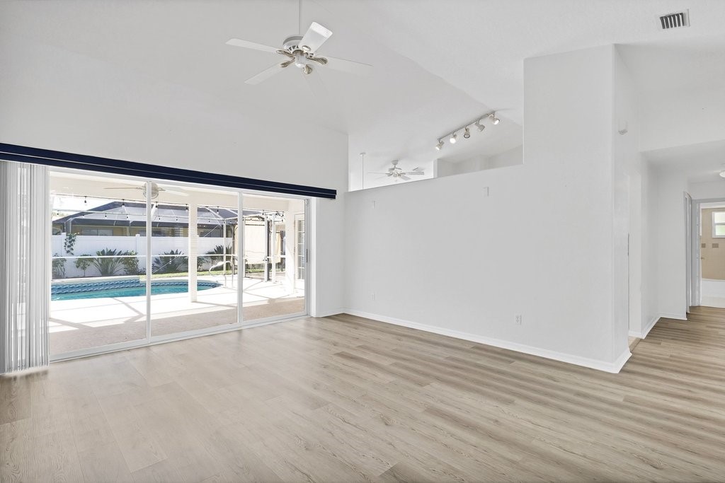 738 Benedictine Terrace Sebastian, FL 32958 - Photo 8 of 33 a view of an empty room with wooden floor and a window