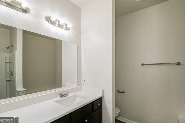 a bathroom with a sink a toilet a mirror and vanity