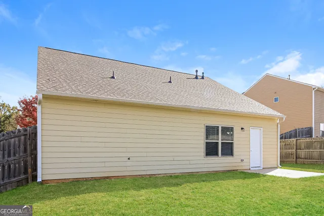a view of a backyard with plants and brick wall