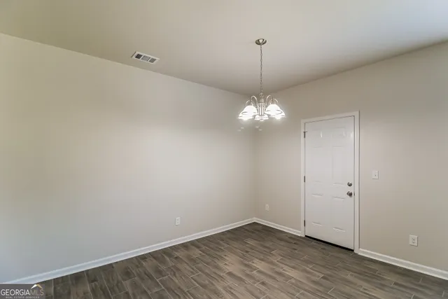 a view of empty room with wooden floor and ceiling fan