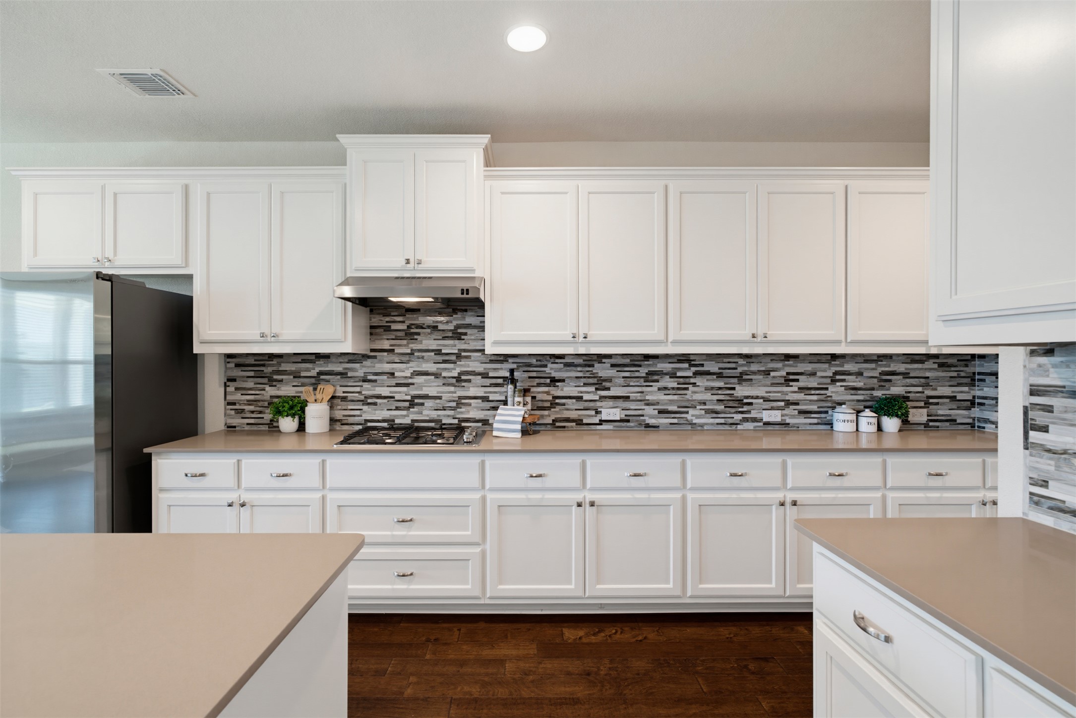 12613 Twisted Root Drive Manchaca, TX 78652 - Photo 7 of 33 White cabinetry, sleek countertops, and a modern tile backsplash complete this inviting kitchen.