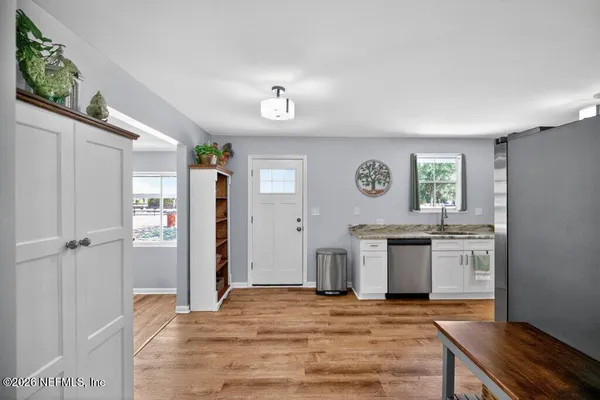 a view of a dining room with furniture a rug and wooden floor