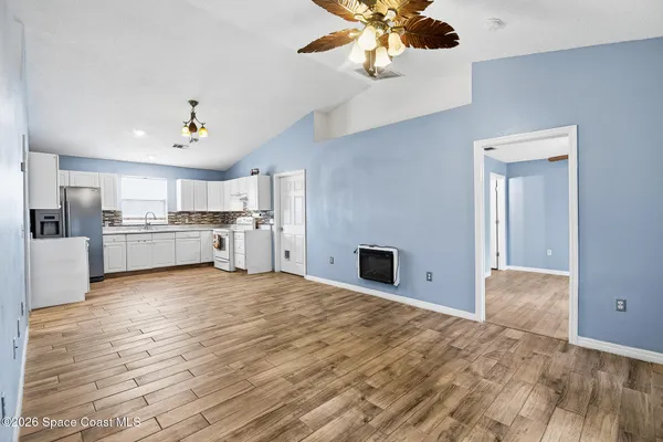 a view of kitchen with kitchen island a sink appliances and cabinets