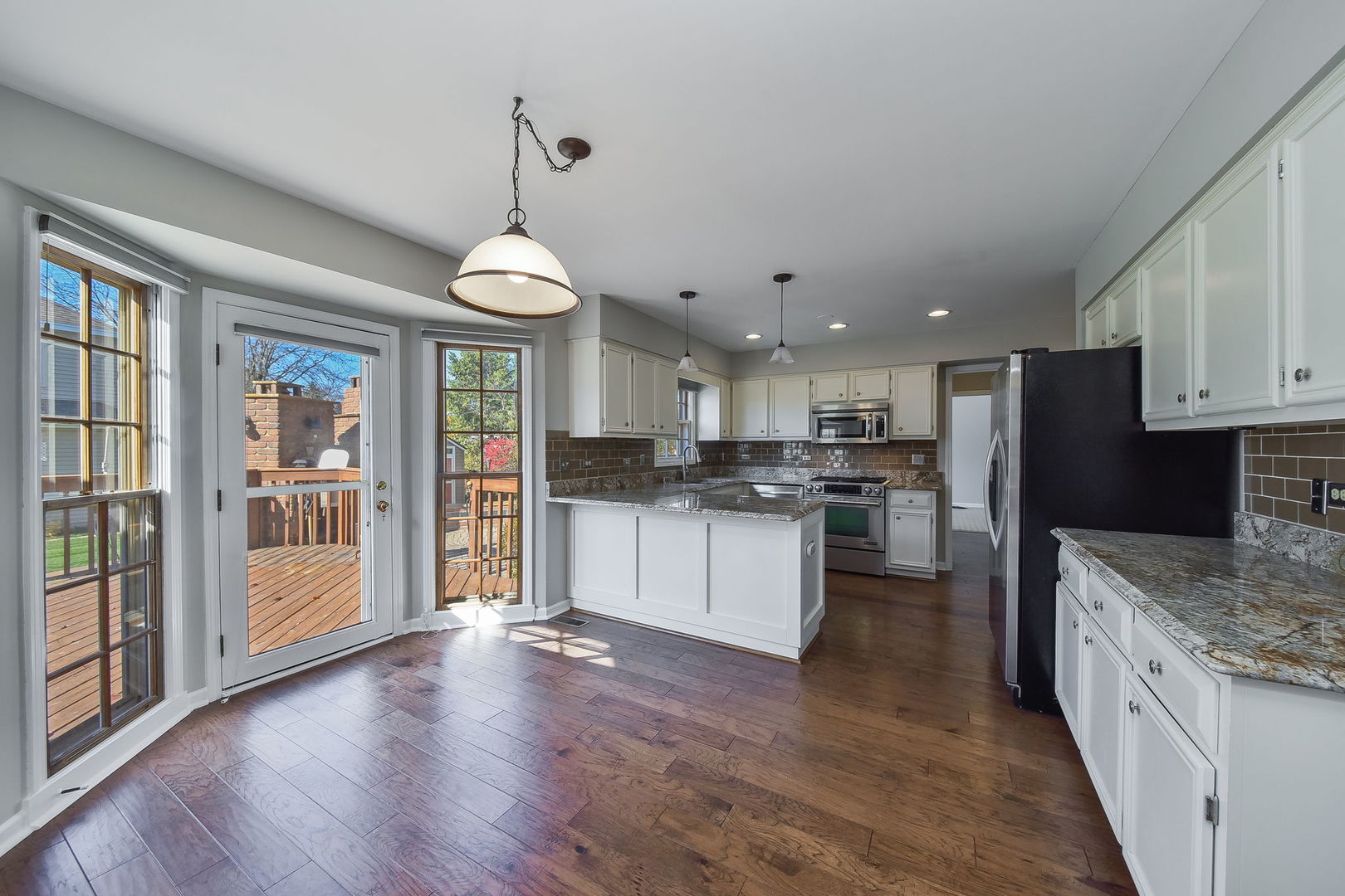 1759 Mundelein Road Naperville, IL 60565 - Photo 7 of 39 a kitchen with stainless steel appliances granite countertop a refrigerator a stove top oven a sink dishwasher and white cabinets with wooden floor