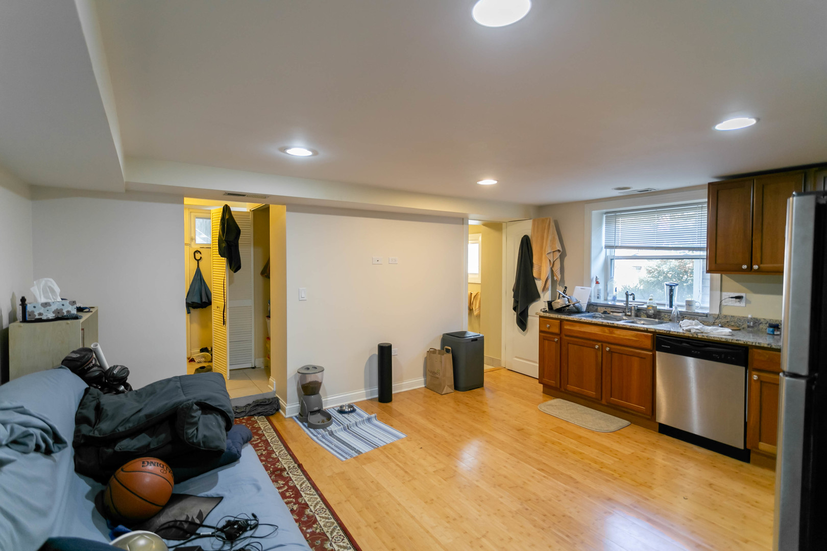 1623 West Huron Street, Unit 1R Chicago, IL 60622 - Photo 3 of 8 a large kitchen with stainless steel appliances granite countertop a refrigerator a sink dishwasher a stove and a dining table with wooden floor