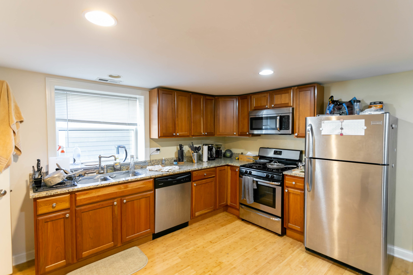 1623 West Huron Street, Unit 1R Chicago, IL 60622 - Photo 4 of 8 a kitchen with a sink a refrigerator a microwave a stove and cabinets