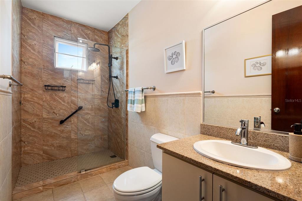 180 Palmas Drive, Unit 48C Humacao, PR 00791 - Photo 18 of 21 a bathroom with a granite countertop sink toilet a mirror and shower