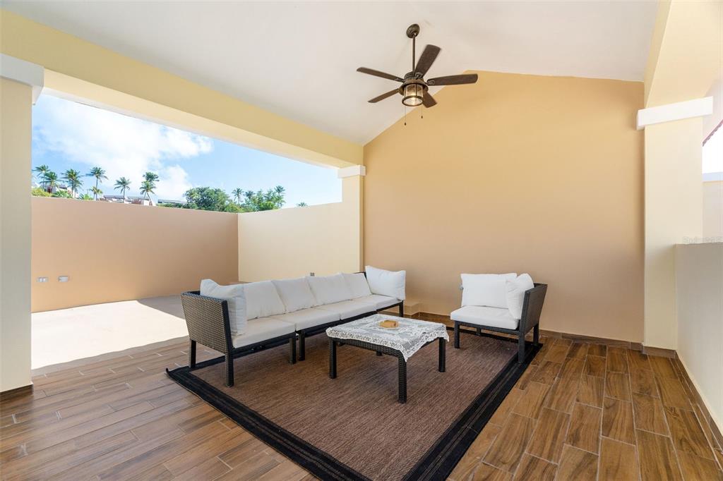180 Palmas Drive, Unit 48C Humacao, PR 00791 - Photo 5 of 21 a living room with a table a rug and a window
