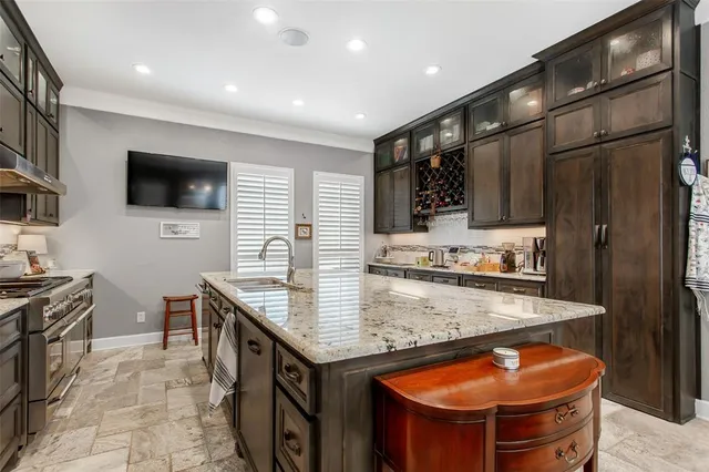 a kitchen with stainless steel appliances granite countertop a sink a stove and a refrigerator