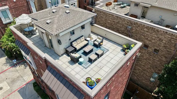 a roof deck with a couch and chairs