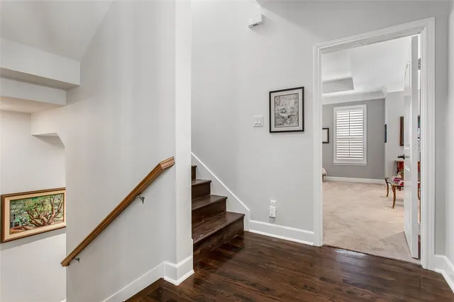 a view of a hallway with wooden floor and stairs