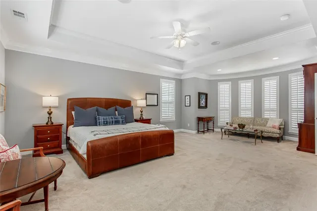 a spacious bedroom with a bed a couch and large windows