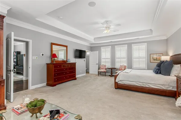 a spacious bedroom with a bed and a chandelier