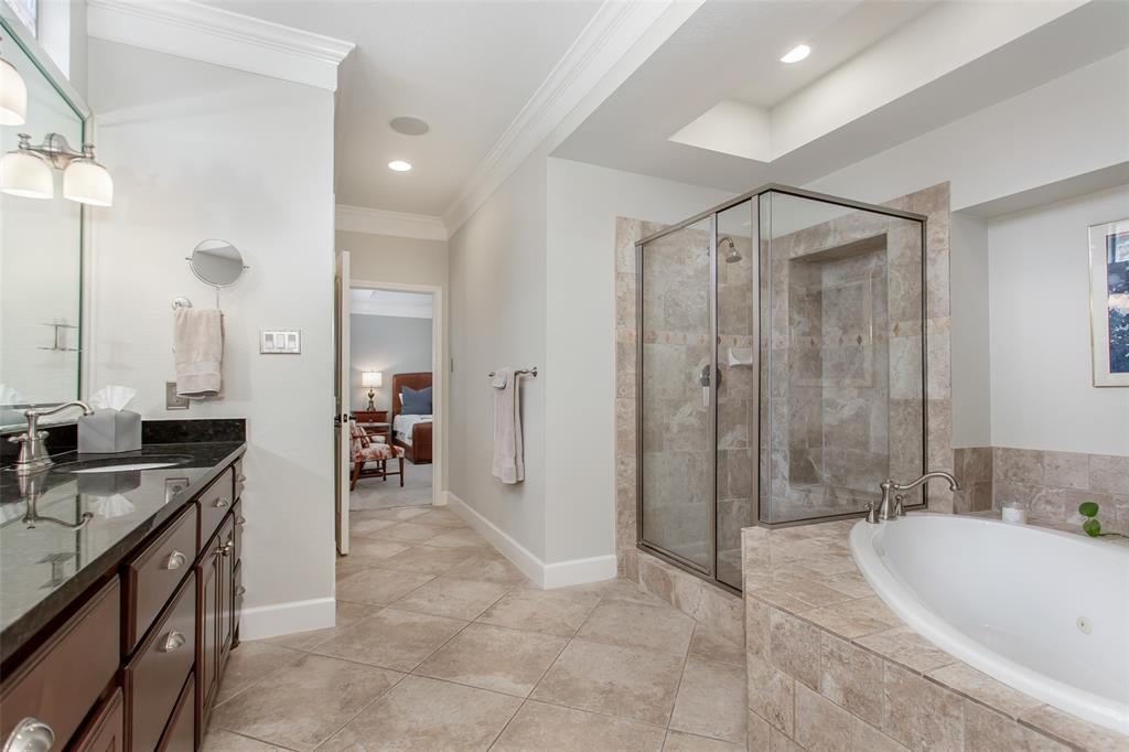 2226 City Market Lane Dallas, TX 75201 - Photo 28 of 40 a bathroom with a granite countertop sink a mirror a bathtub and shower