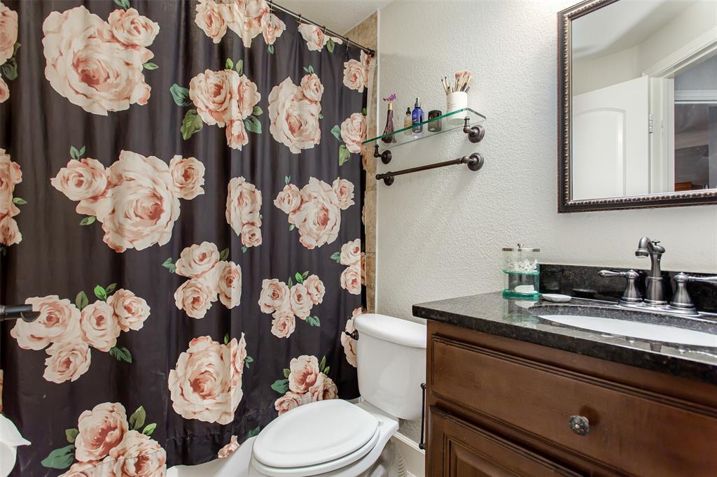 2226 City Market Lane Dallas, TX 75201 - Photo 32 of 40 a bathroom with a granite countertop toilet sink mirror and shower curtain
