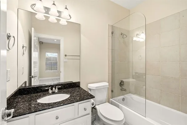 a bathroom with a granite countertop sink toilet and shower