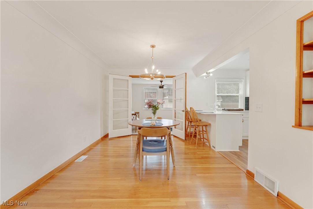 3841 Bethany Road Cleveland, OH 44118 - Photo 6 of 9 Dining area featuring a chandelier, light wood-style floors, and baseboards