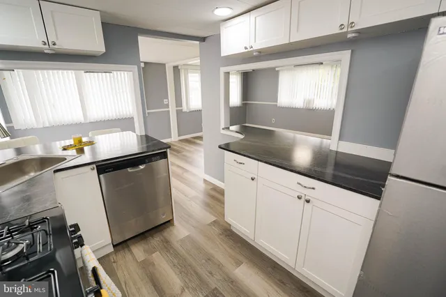 a kitchen with granite countertop white cabinets and white appliances