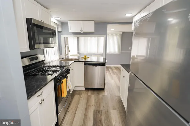 a kitchen with granite countertop a sink stove and refrigerator